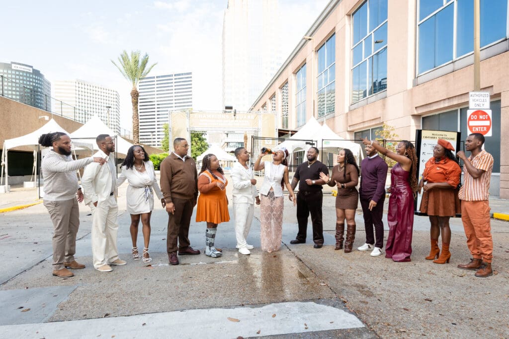 New Orleans wedding party celebrating with champagne in front of the New Orleans Superdome