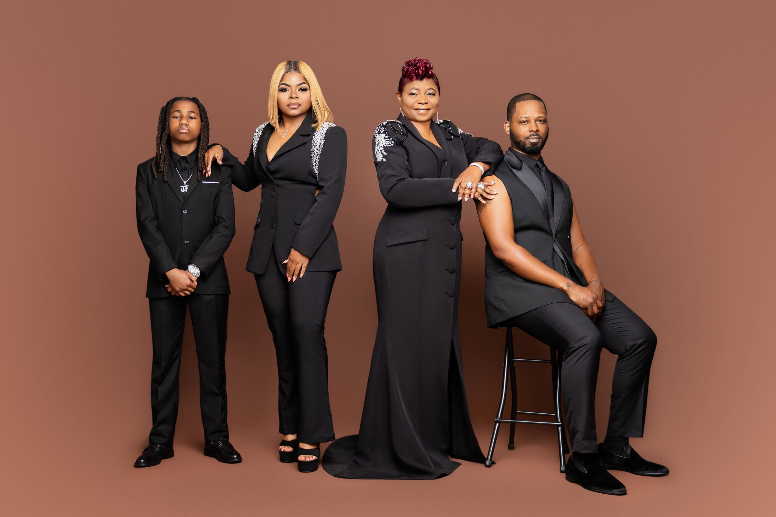 stylish family of four dressed in black posing together in a studio portrait session in New Orleans